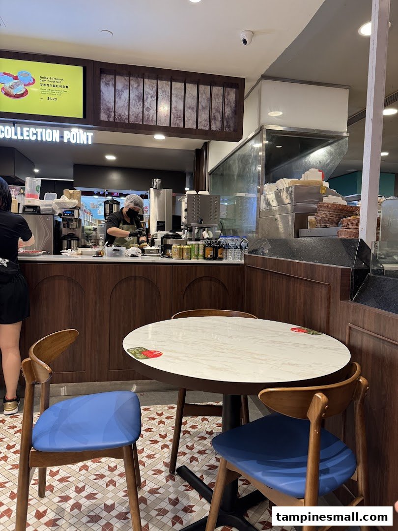 Interior view of The Hainan Story Coffee House, featuring the service counter, staff, and a cozy seating area.