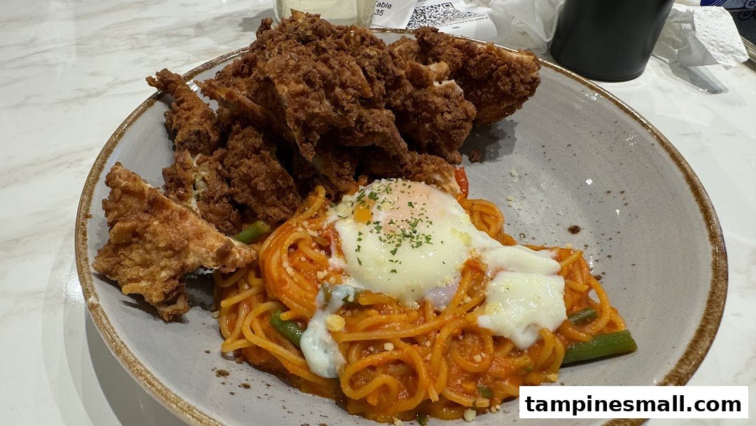 A close-up of crispy fried chicken served with spaghetti and a poached egg.