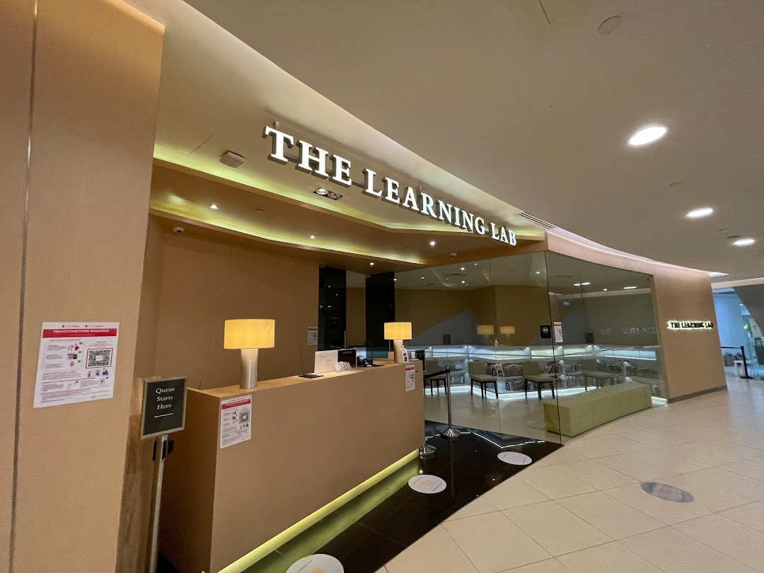 The modern entrance of The Learning Lab at Tampines Mall, featuring a reception desk and glass-fronted interior.