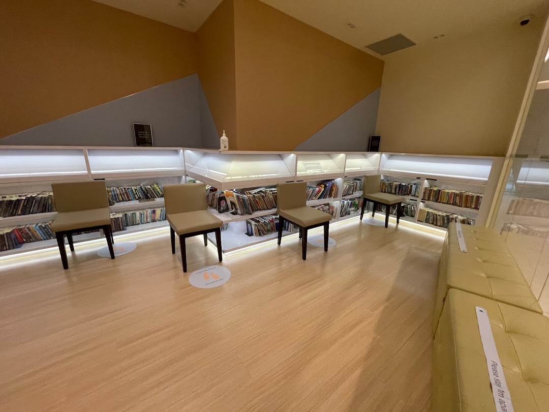 An interior view of a quiet waiting or reading area with bookshelves and comfortable seating.