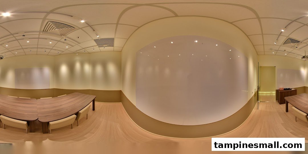 A spacious, modern learning environment with large tables, comfortable seating, and multiple whiteboards.