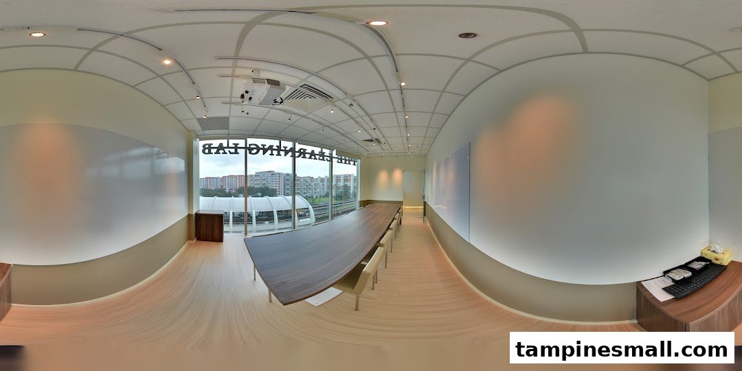A modern, spacious classroom or meeting room with a long table, whiteboards, and a city view.