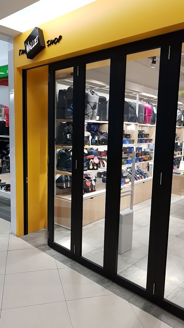 The shopfront of 'The Wallet Shop' featuring a bright yellow facade and a display of various bags and wallets.