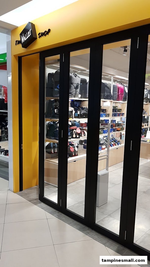 The shopfront of 'The Wallet Shop' featuring a bright yellow facade and a display of various bags and wallets.