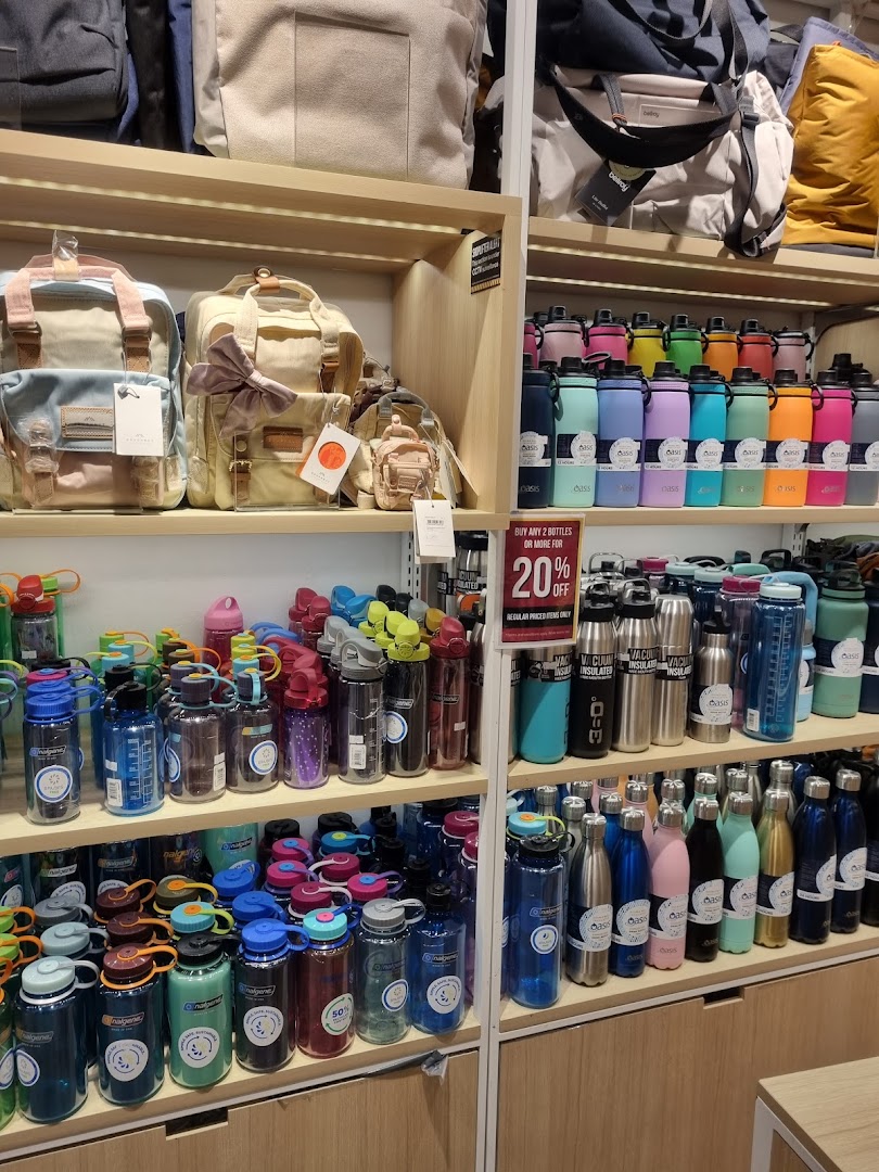 Shelves displaying a wide variety of colorful water bottles and stylish bags inside a retail store.
