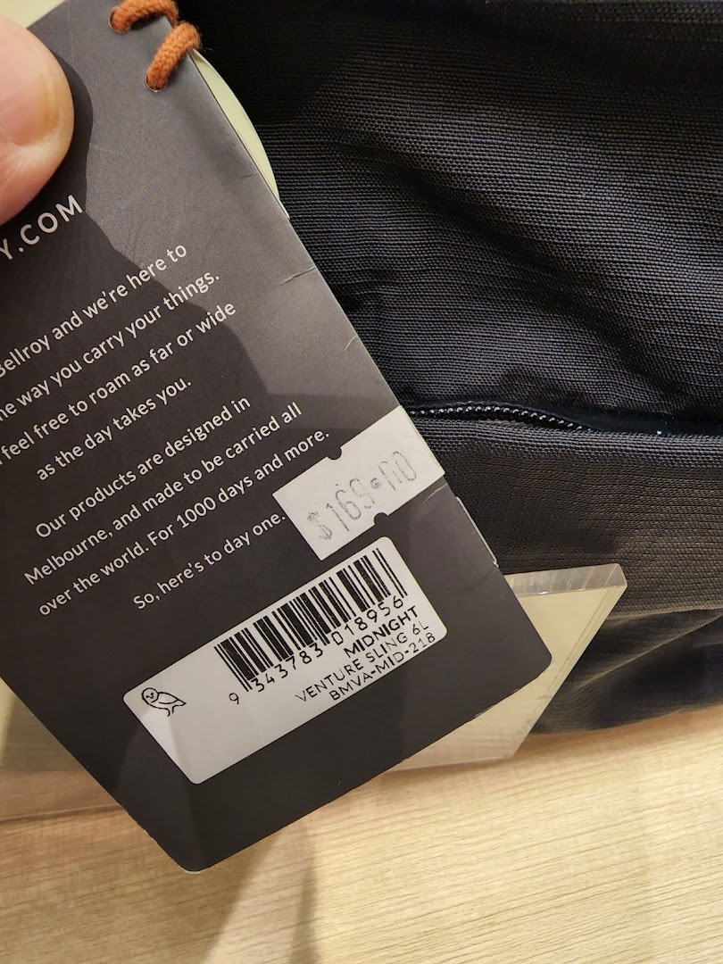 Close-up of a Bellroy Venture Sling product tag displaying price and item details.