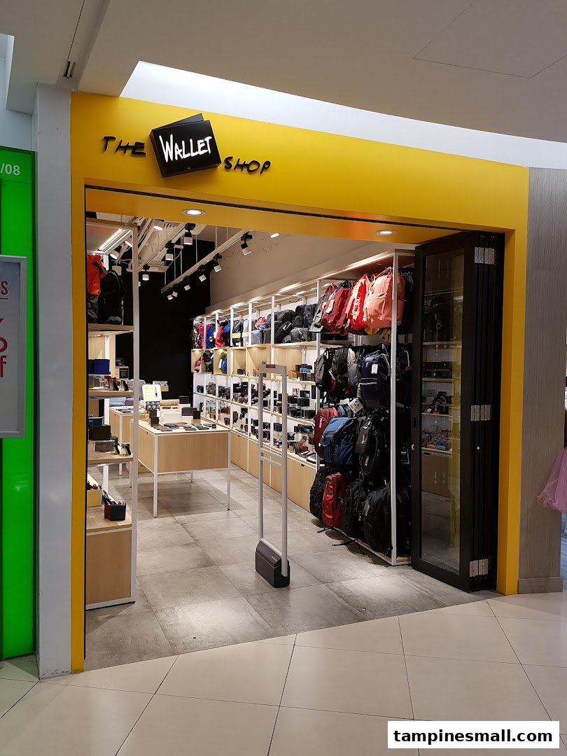 The bright yellow storefront of The Wallet Shop, showcasing a wide array of wallets, bags, and accessories.