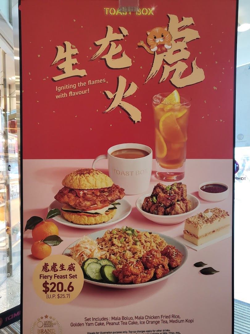 A vibrant promotional poster for Toast Box's 'Fiery Feast Set' featuring various dishes and drinks.