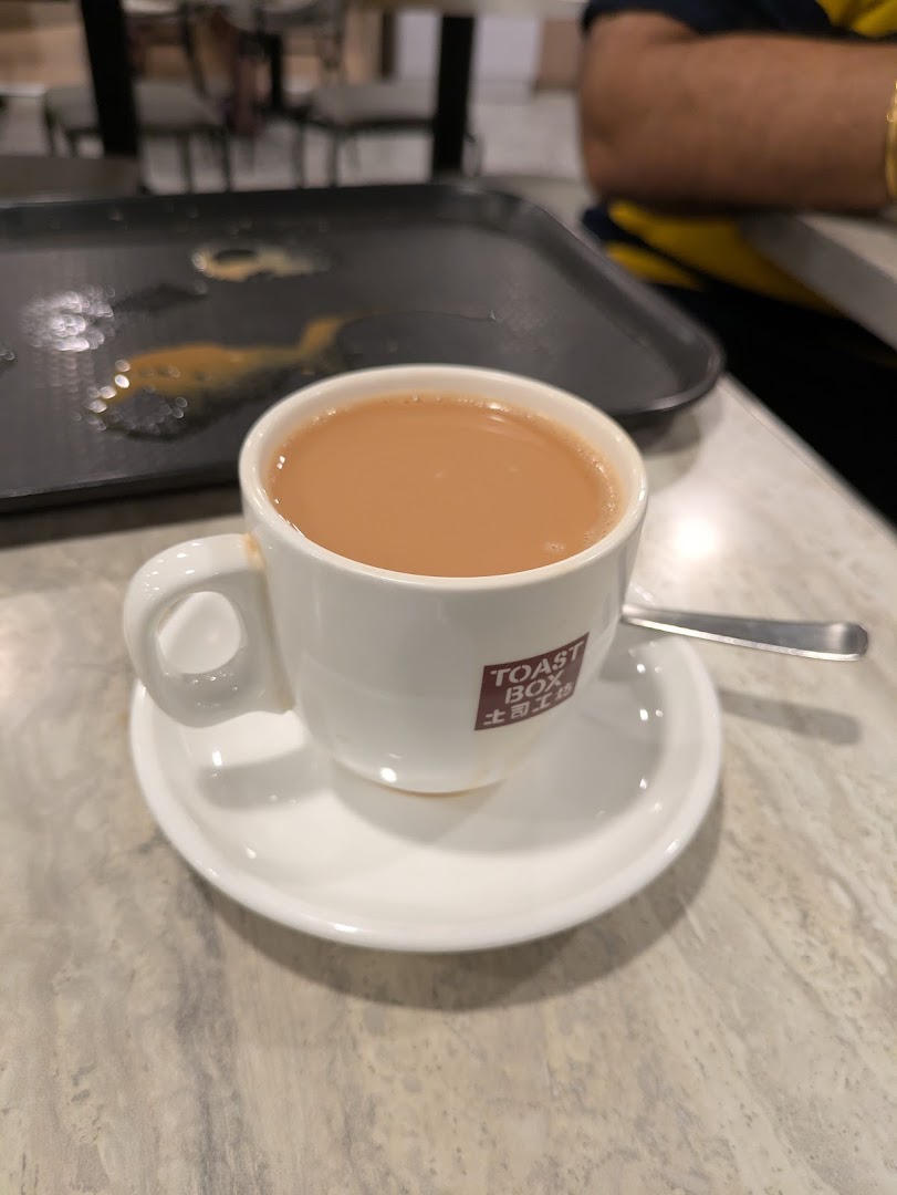 A close-up of a cup of traditional coffee or tea from Toast Box, served on a table.