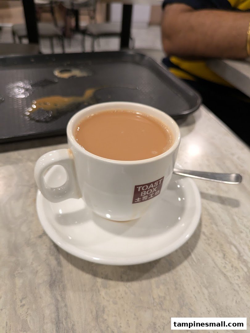 A close-up of a cup of traditional coffee or tea from Toast Box, served on a table.