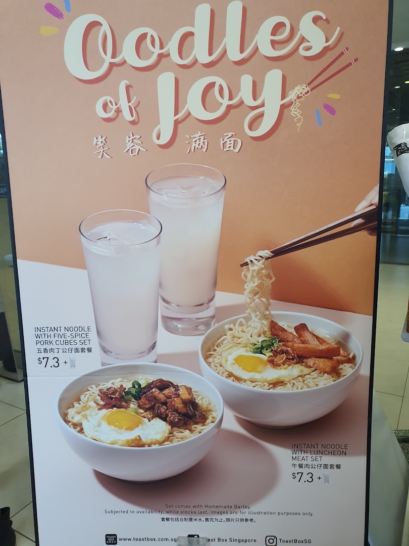 A promotional poster for Toast Box featuring instant noodle sets with pork cubes and luncheon meat, served with barley.