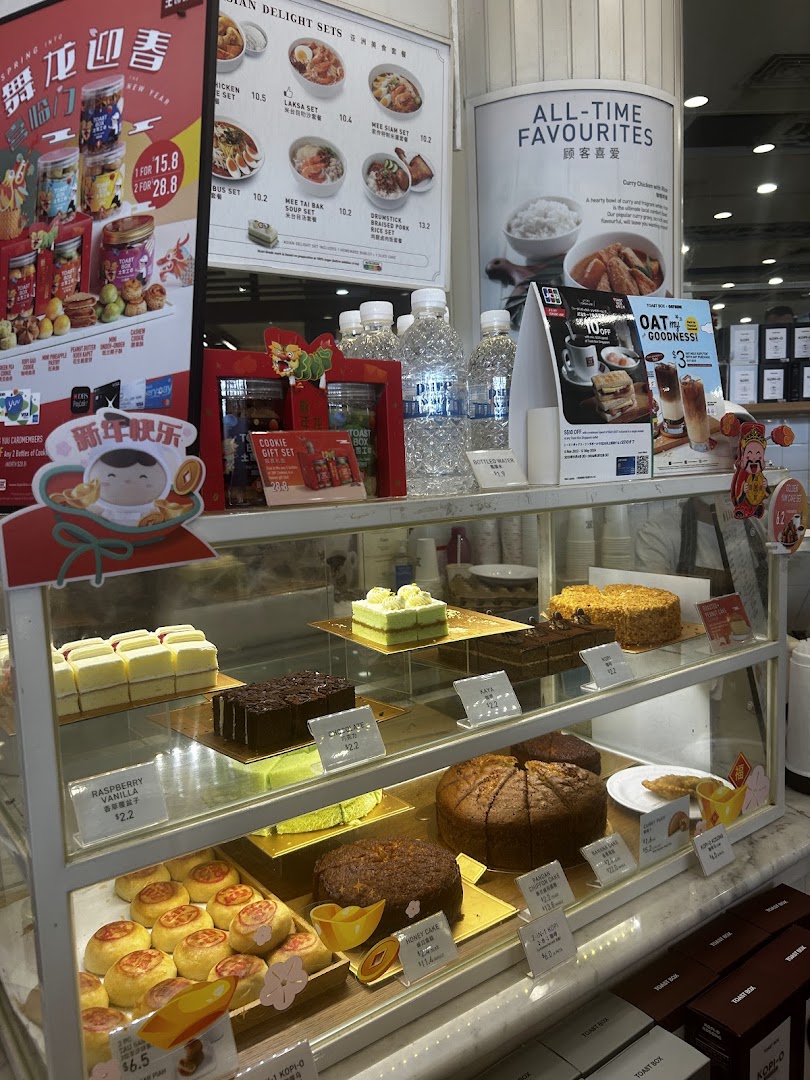 A vibrant display case showcasing an assortment of freshly baked cakes and pastries at Toast Box.