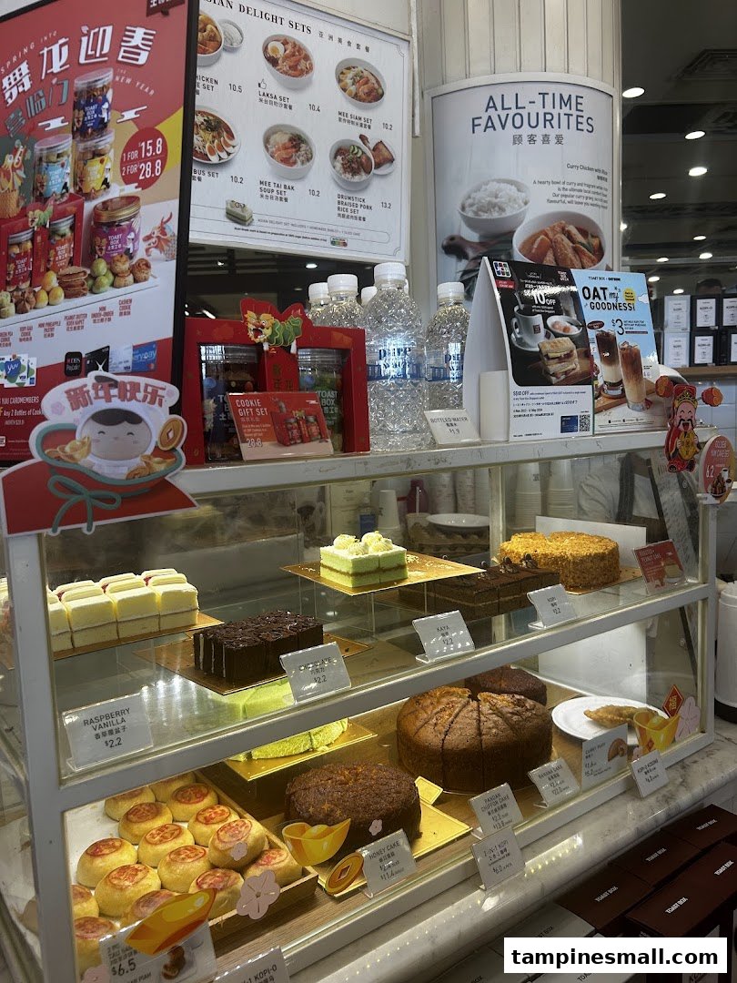 A vibrant display case showcasing an assortment of freshly baked cakes and pastries at Toast Box.