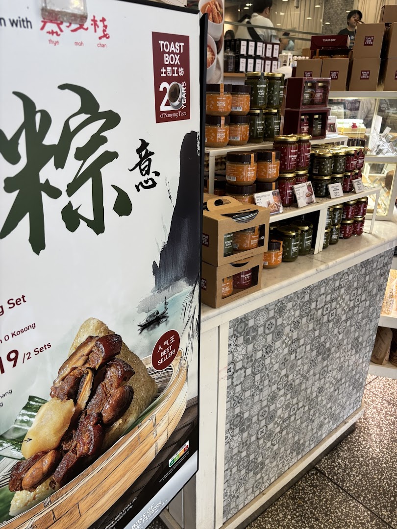 A Toast Box display featuring a Zongzi promotional poster and shelves stocked with various spreads and jams.