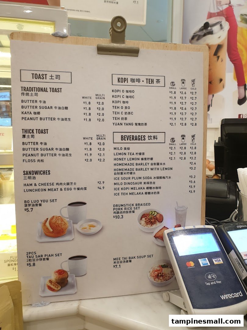 A detailed menu board displaying various toast, coffee, tea, beverages, sandwiches, and set meals with prices.