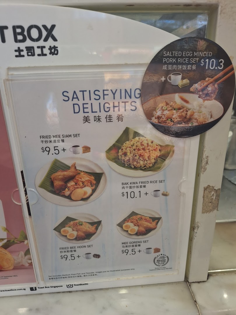 A menu board displaying various set meals with prices and images from Toast Box.