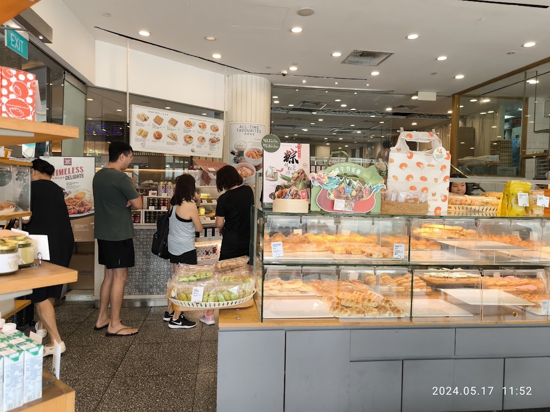Customers browse a wide selection of pastries and baked goods at Toast Box's display counter.