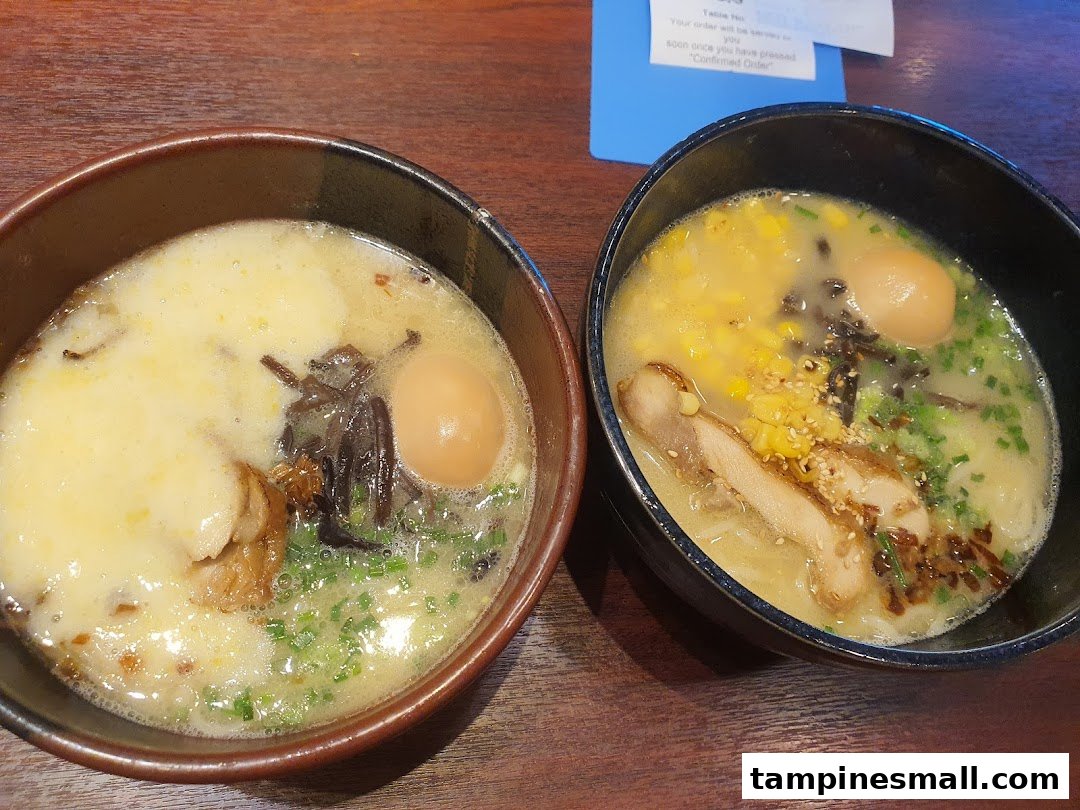 Two bowls of delicious ramen with various toppings, including eggs, corn, and meat, on a wooden table.