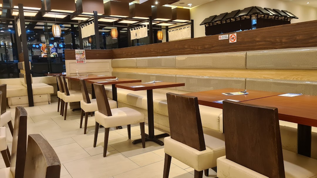 A clean and inviting dining area with wooden tables, comfortable seating, and Japanese-inspired decor.