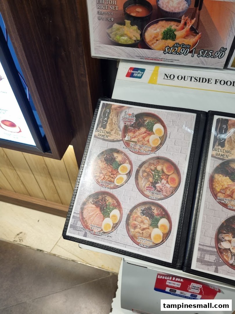 A close-up of Tokyo Shokudo's menu display, showcasing various ramen dishes and a rice set with prices.