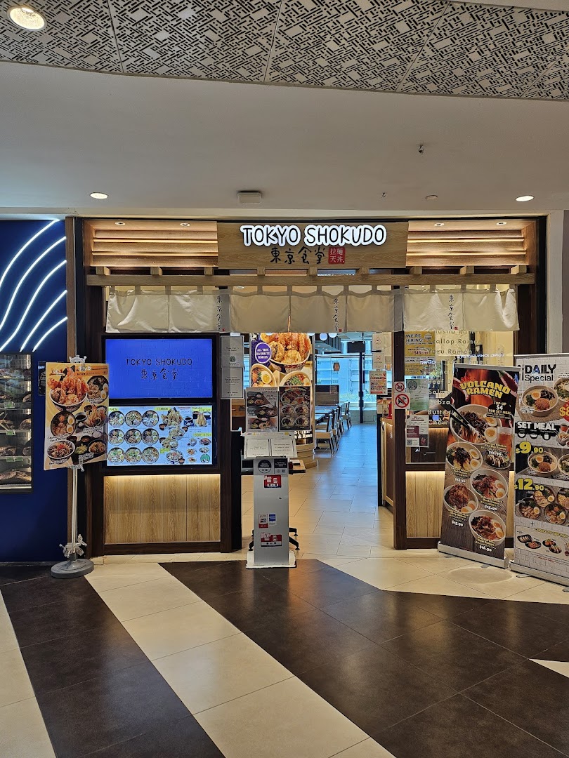 The inviting entrance of Tokyo Shokudo, a Japanese restaurant, featuring digital displays and promotional banners.