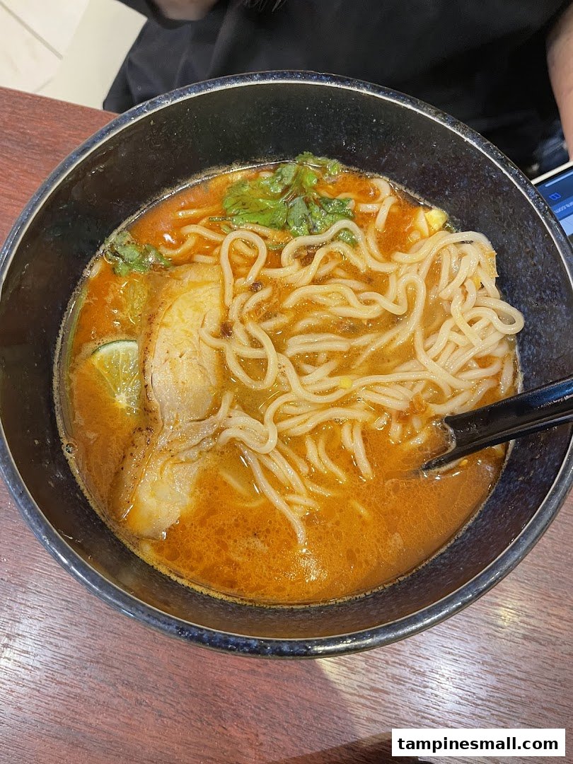 A close-up of a vibrant bowl of ramen with noodles, rich broth, meat, and fresh herbs.