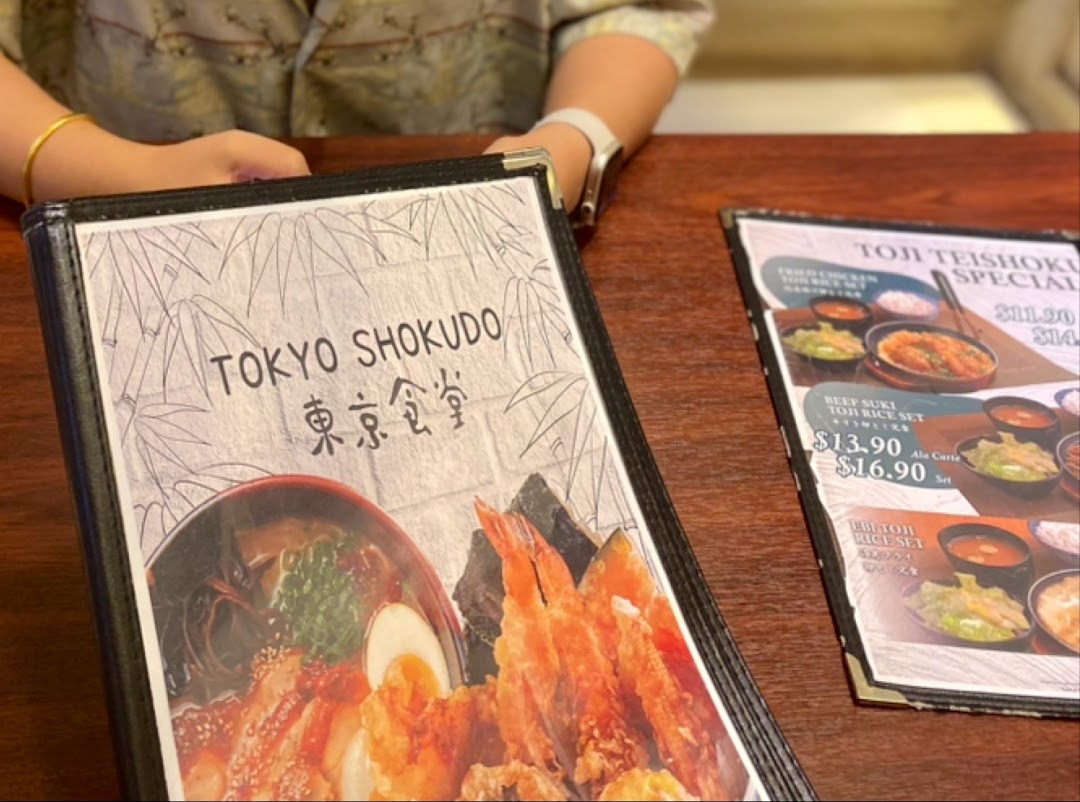 A close-up of a Tokyo Shokudo menu displaying Japanese dishes and prices.