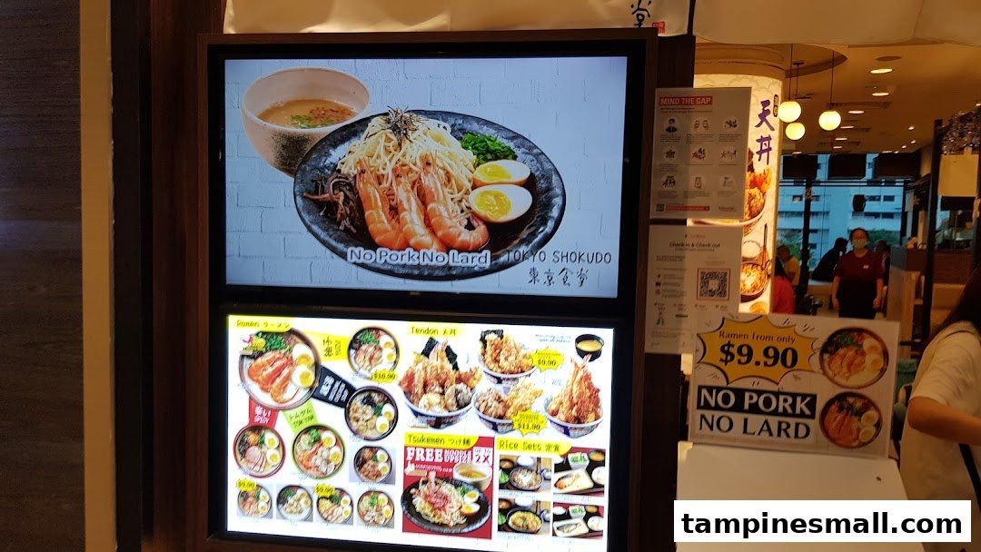 Digital menu boards display Japanese ramen, tendon, and rice sets with prices and 'No Pork No Lard' signage.