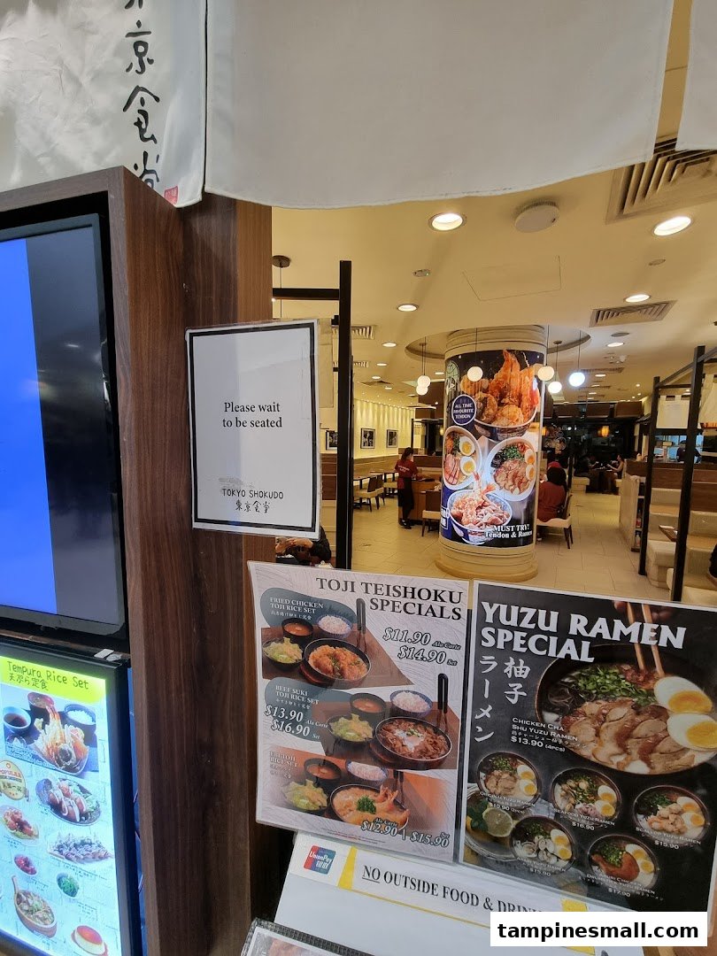 View of Tokyo Shokudo's entrance, featuring menu displays for Toji Teishoku and Yuzu Ramen specials.