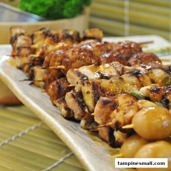A close-up of various grilled skewers, including chicken and possibly quail eggs, on a serving platter.