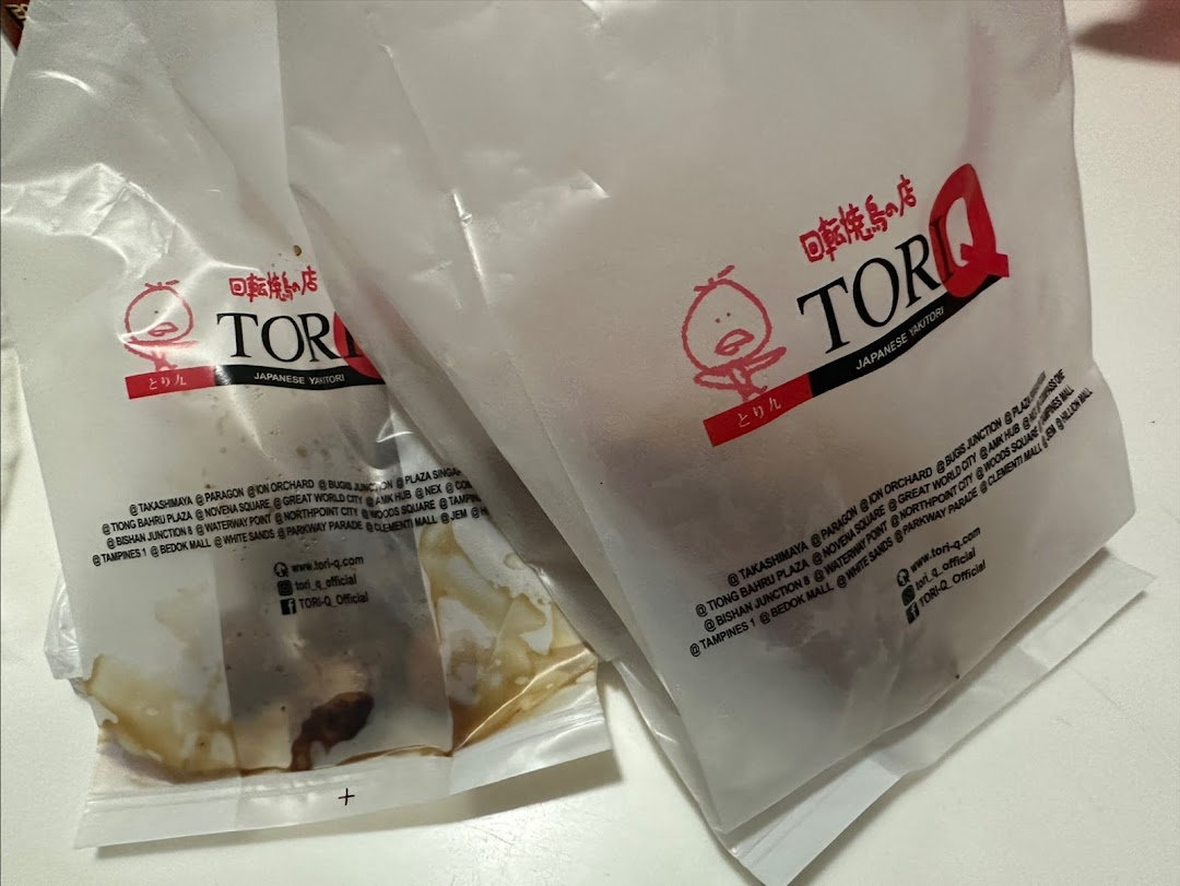Two branded plastic bags from TORI-Q, a Japanese Yakitori shop, containing takeaway food.