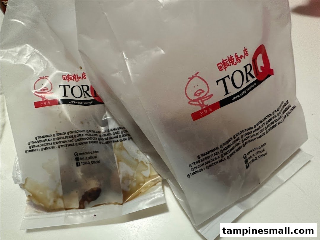 Two branded plastic bags from TORI-Q, a Japanese Yakitori shop, containing takeaway food.