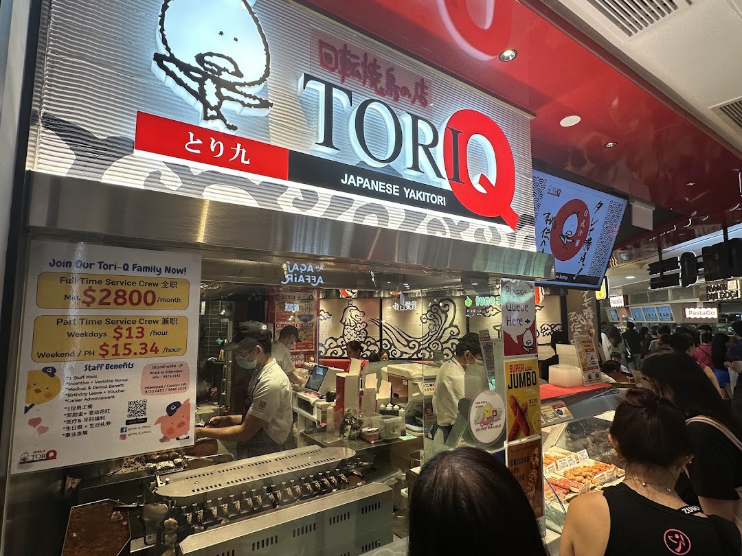 The bustling front of TORI-Q, a Japanese yakitori shop, with staff preparing food and customers queuing.