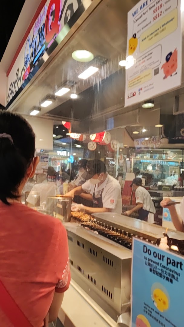 Staff prepare delicious skewers behind the counter at TORI-Q, showcasing fresh cooking.