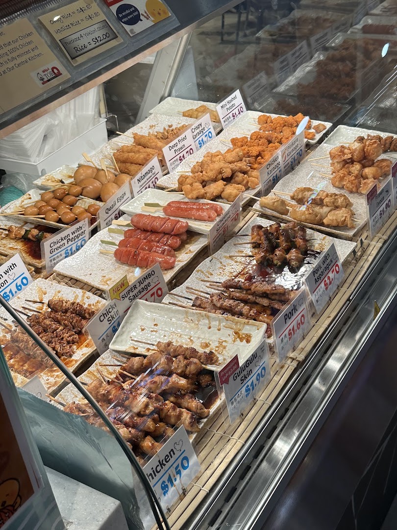 A vibrant display case showcasing a variety of Japanese-style skewers and fried snacks.