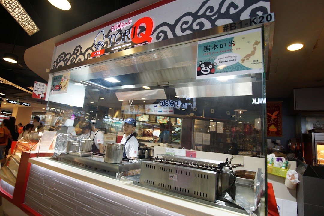 A bustling TORI-Q Japanese Yakitori stall with staff preparing food and a prominent brand sign.