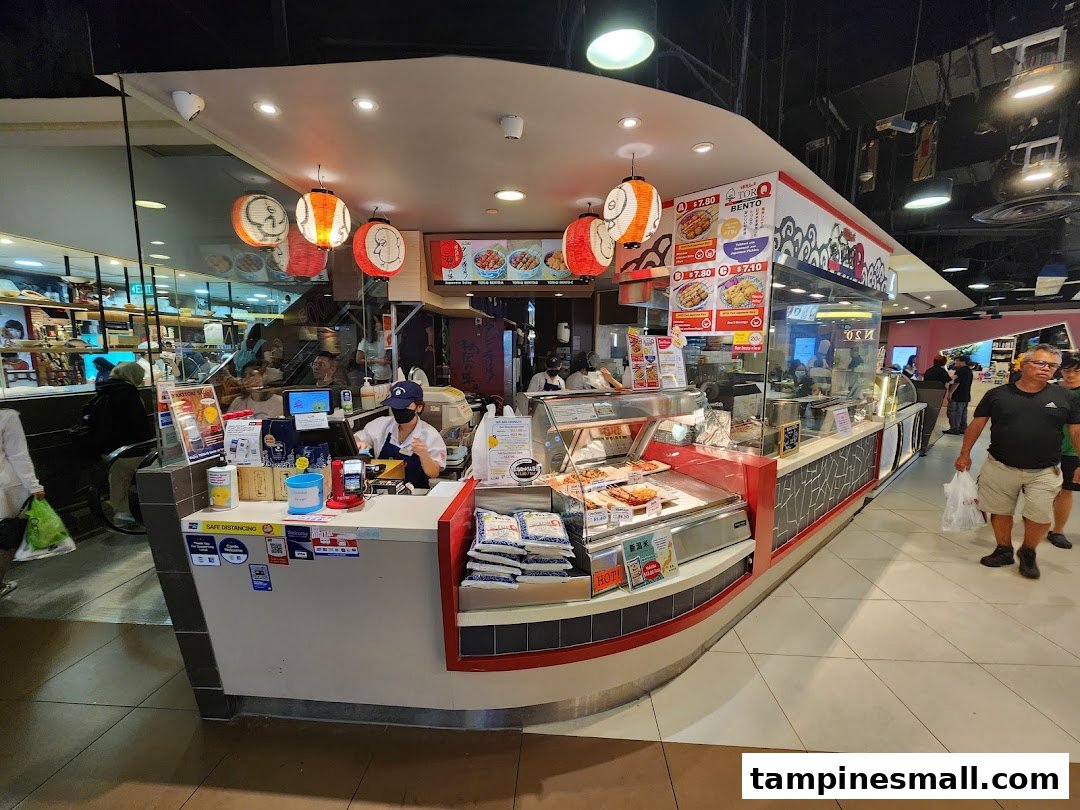A bustling TORI-Q food stall showcasing its counter, food displays, and staff serving customers.
