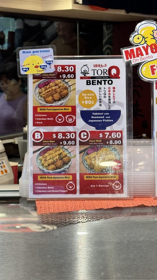 A close-up view of TORI-Q's menu board displaying various bento and value meal options.