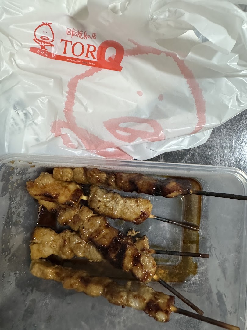 Delicious yakitori skewers in a takeaway container with a TORI-Q branded bag.