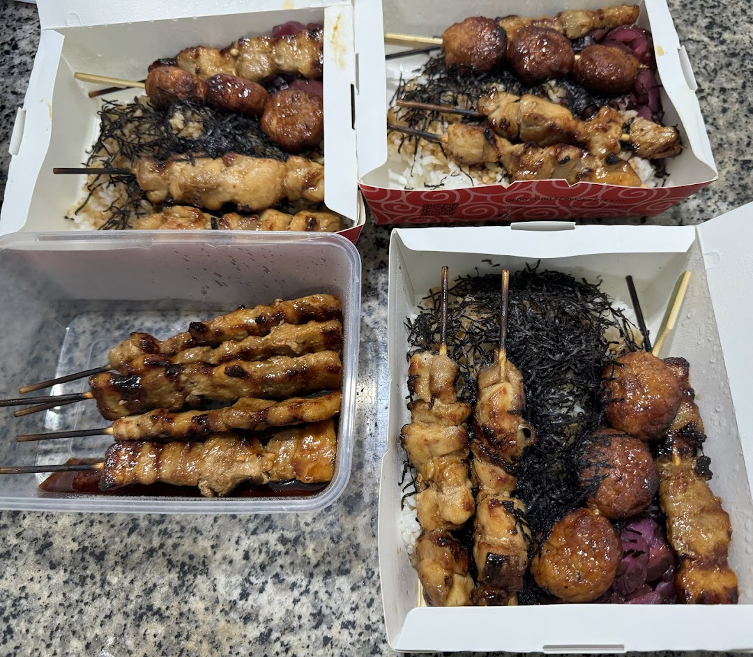 Multiple takeaway boxes filled with delicious yakitori skewers, rice, and seaweed from TORI-Q.