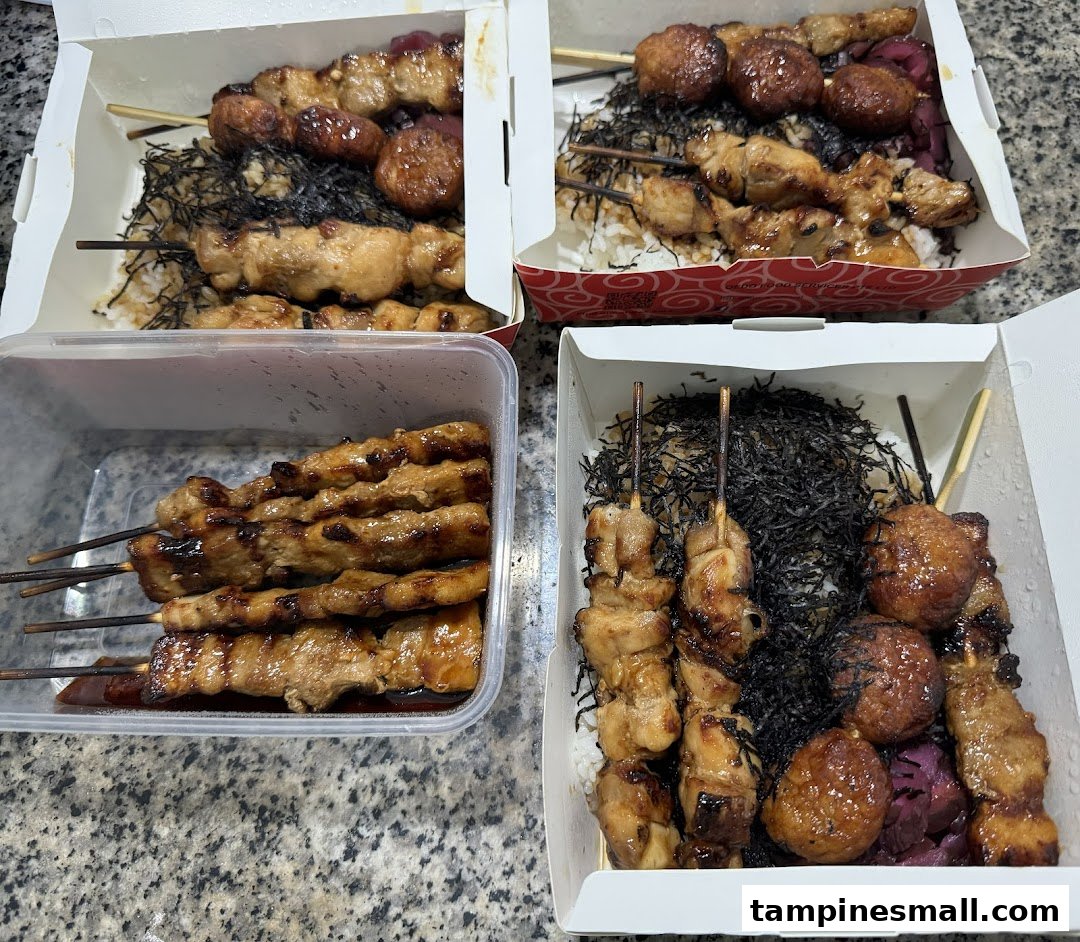 Multiple takeaway boxes filled with delicious yakitori skewers, rice, and seaweed from TORI-Q.