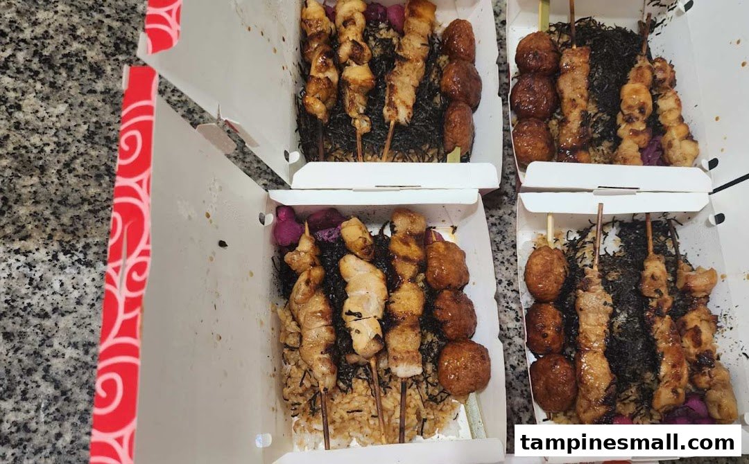 Multiple open takeaway boxes filled with various grilled skewers, rice, and toppings from TORI-Q.