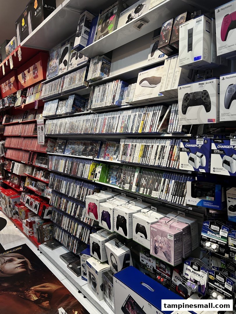 Shelves filled with a vast collection of video games, consoles, and gaming accessories in a retail store.