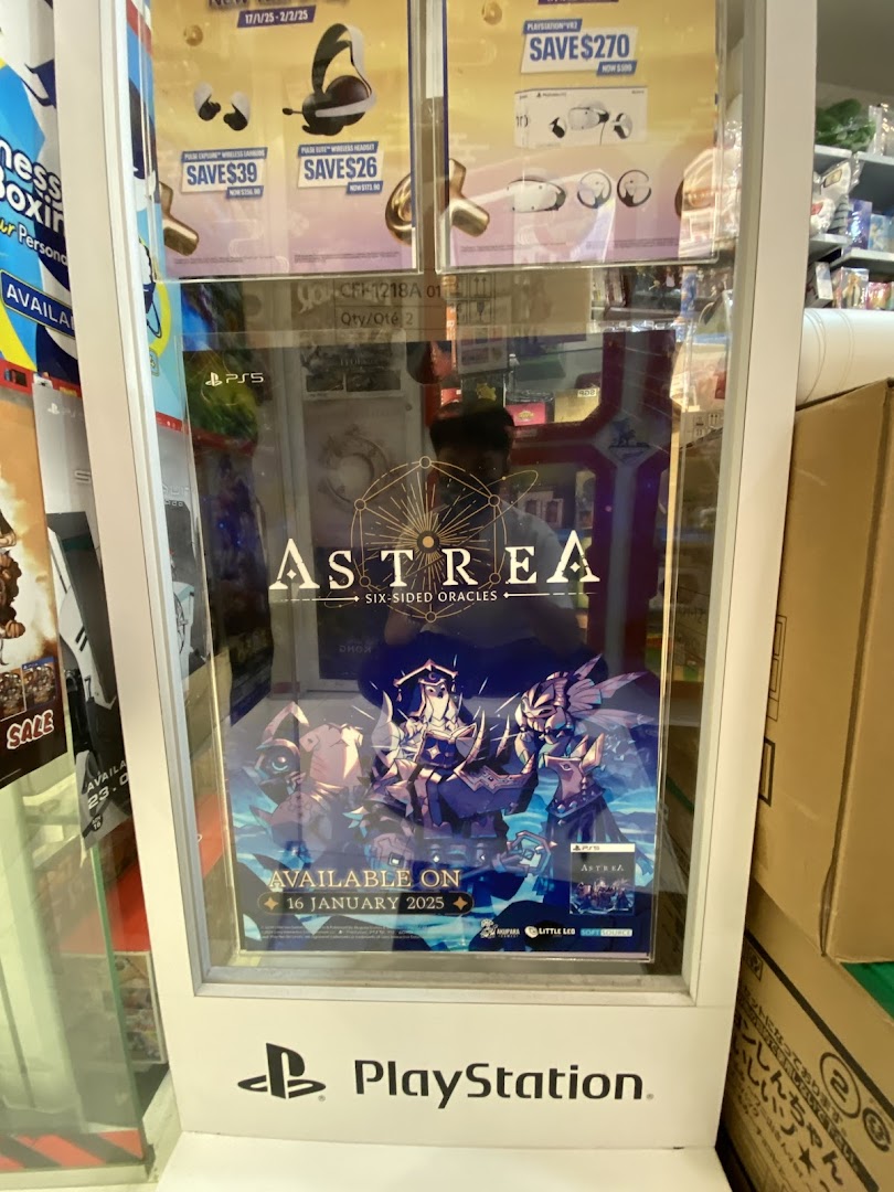 A PlayStation display stand inside a shop, showcasing game promotions and a new game release.