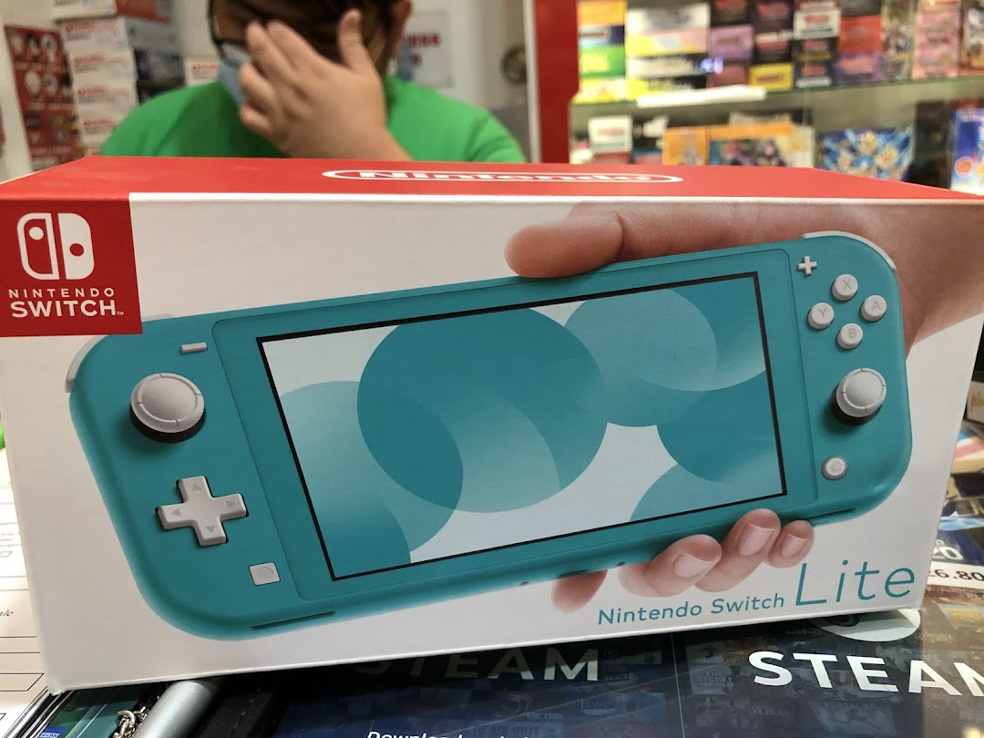 Close-up of a Nintendo Switch Lite box in a toy and game shop, with a customer in the background.