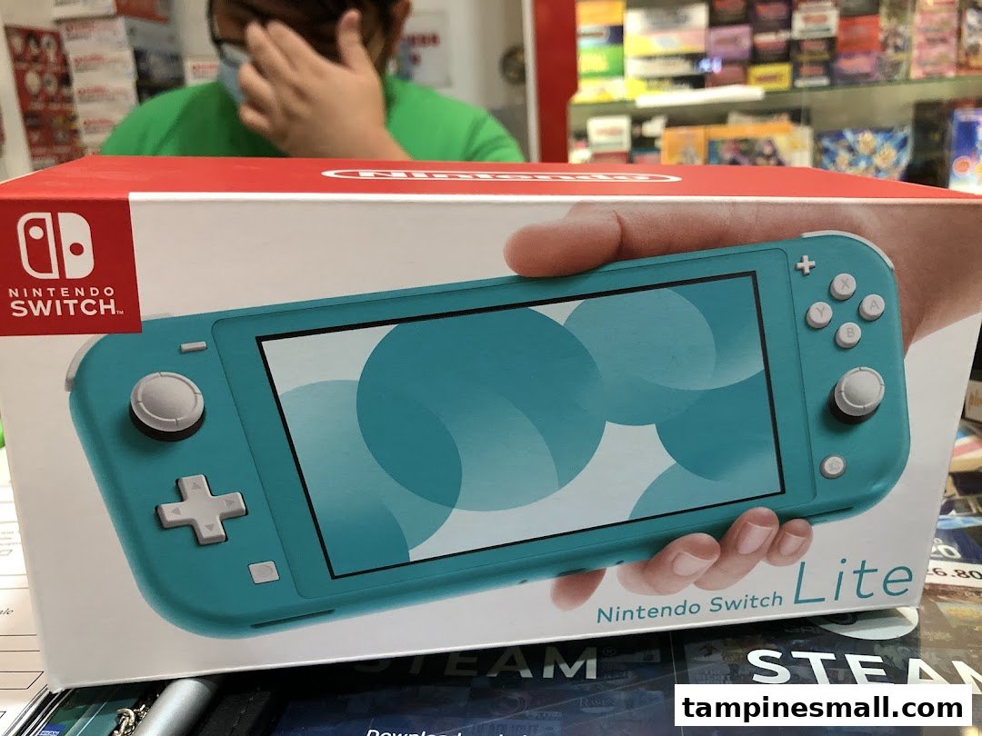 Close-up of a Nintendo Switch Lite box in a toy and game shop, with a customer in the background.