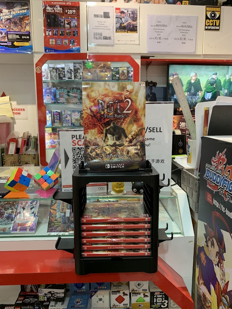 An interior shot of a game and toy shop, featuring video games, Rubik's cubes, and promotional posters.