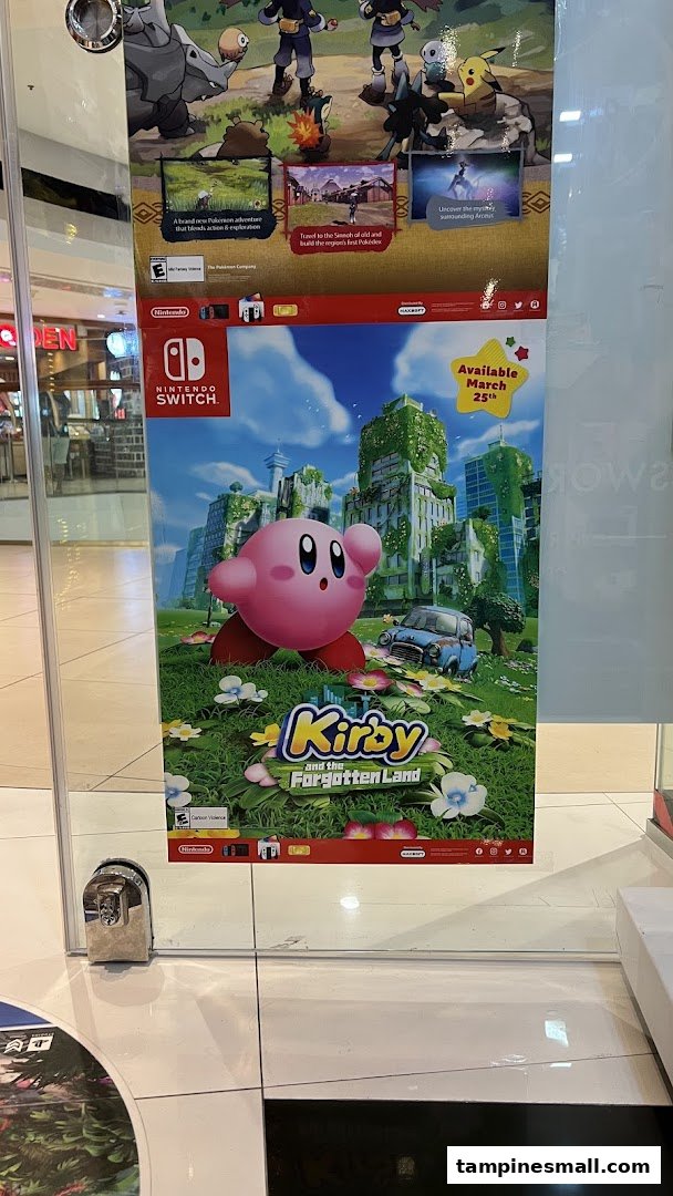 Promotional posters for Nintendo Switch games, including Kirby and Pokémon, displayed inside a retail shop.