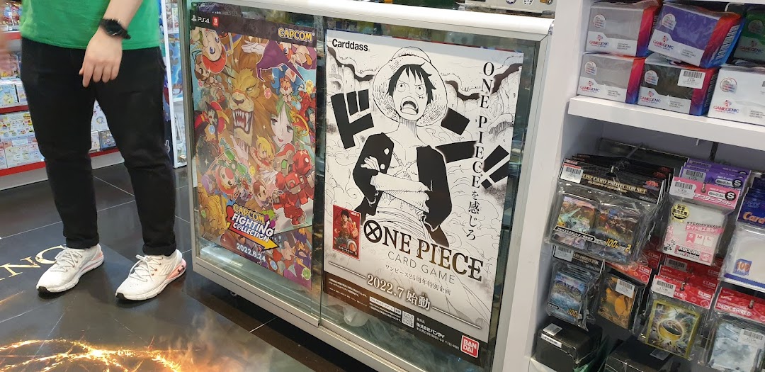 A display case featuring game posters and card game accessories inside a toy and game shop.