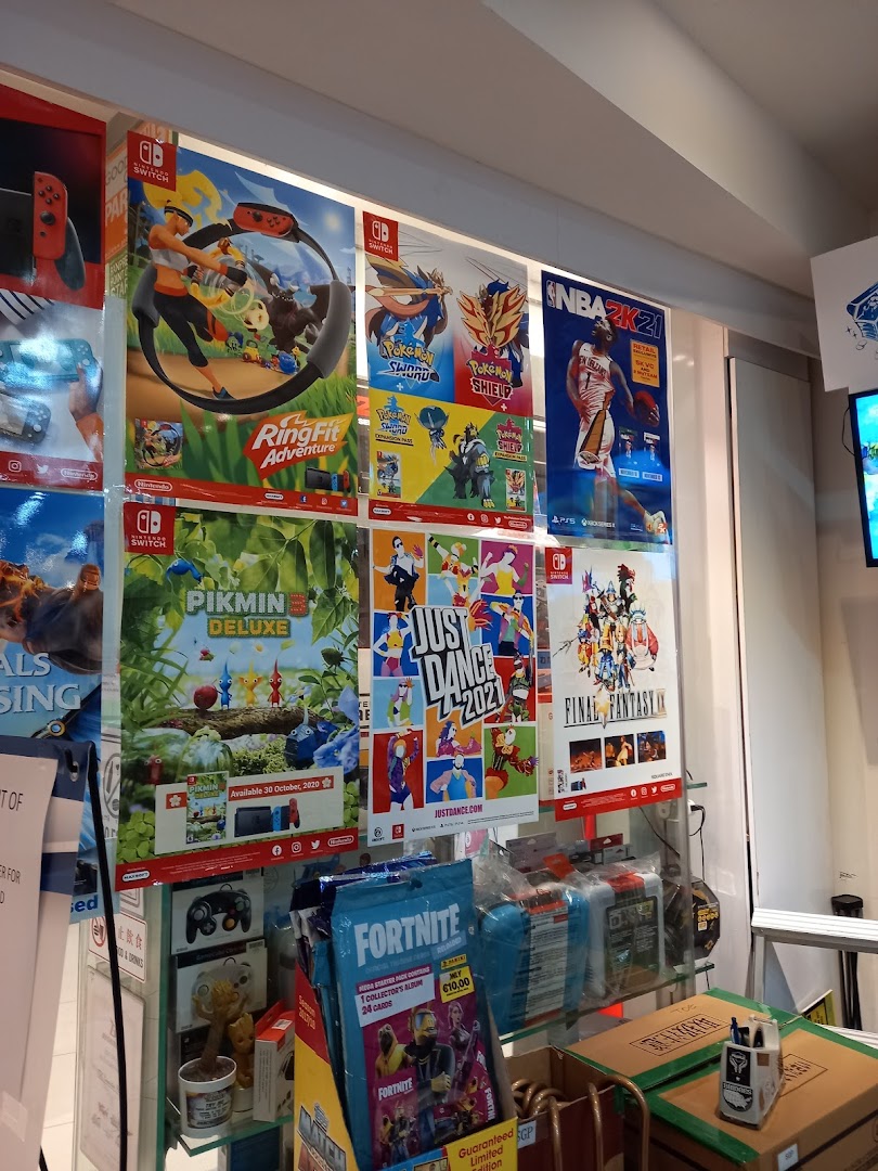 A vibrant display of video game posters and merchandise, including popular titles like Ring Fit Adventure and Fortnite.